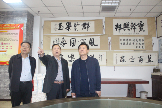 02、万荣客人在秘书长张云山陪同下参观会馆建设和工作展板.jpg